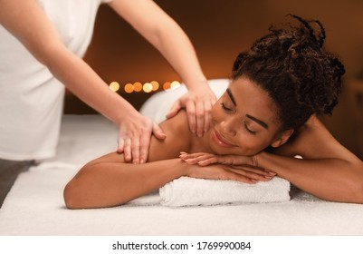 Young Black Woman Getting Massage From Female Therapist At Spa