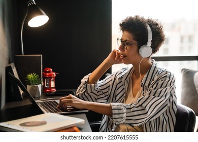 Young Black Woman In Headphones Working With Laptop At Home