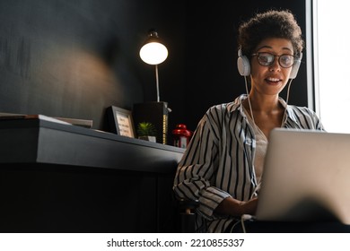 Young Black Woman In Headphones Working With Laptop At Home