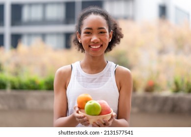 Young Black Woman Holding Low Sugar Fruits In The Wooden Bowl To Diet And Body Slim Fit Including Getting Vitamin C, Fiber From Natural Fruits After Finish Outdoor Workout At Home, Raw Food Snack 