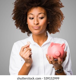 Young Black Woman Holding A Piggy Bank