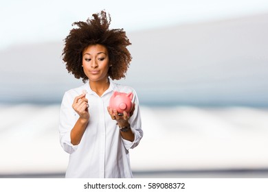 Young Black Woman Holding A Piggy Bank