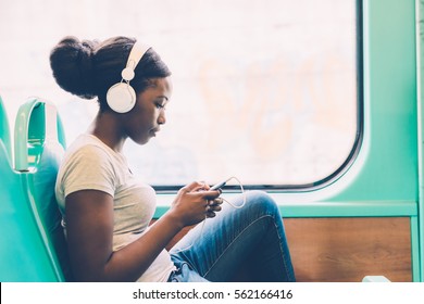 Young Black Woman Listening Music Travelling By Bus Using Smart Phone Hand Hold, Pensive - Thoughtful, Thinking Future, Music Concept