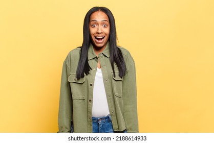 Young Black Woman Looking Happy And Pleasantly Surprised, Excited With A Fascinated And Shocked Expression