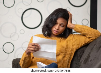 Young Black Woman Looks Unhappy While Reading A Letter