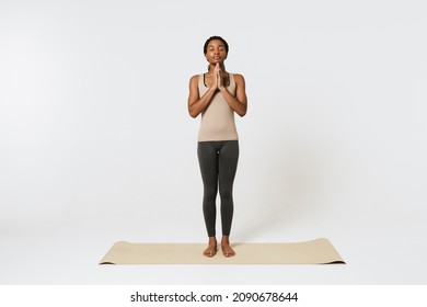 Young Black Woman Meditating During Yoga Practice On Mat Isolated Over White Background