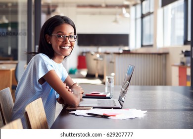 Young Black Woman In Office With Laptop Smiling To Camera