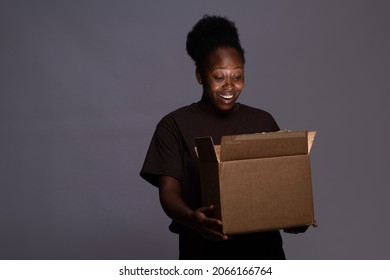 Young Black Woman Opening A Box