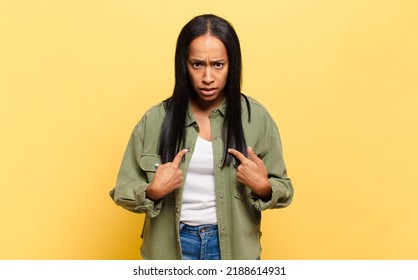 Young Black Woman Pointing To Self With A Confused And Quizzical Look, Shocked And Surprised To Be Chosen