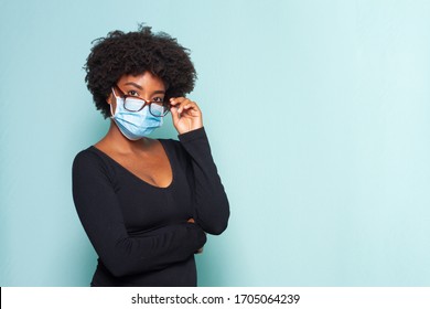 young black woman with black power hair wearing protective mask with reading glasses - Shutterstock ID 1705064239