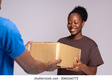 Young Black Woman Receiving A Package From A Delivery Worker