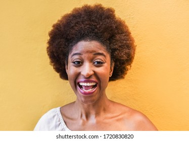 Young Black Woman Standing Isolated Over Yellow Background - African Girl Laughing And Smiling On Phone Camera - Lifestyle And Technology Concept