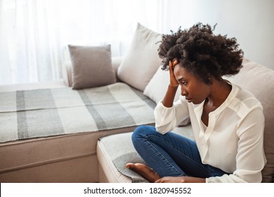 Young black woman suffering strong headache. Shot of a young woman experiencing a difficult moment.