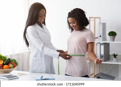 Young Black Woman Taking Body Measurements At Dietologist, Clinic Interior