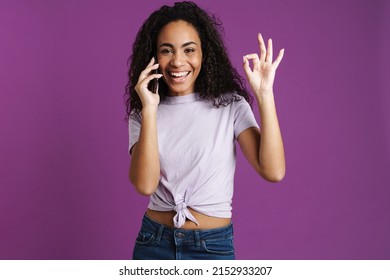 Young Black Woman Talking On Mobile Phone And Gesturing Isolated Over Purple Background