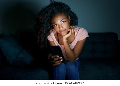 Young Black Woman Texting On Mobile Phone At Night