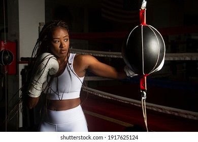 Young Black Woman Training Boxing In Gym With The Ring Boxing Background. Determination, Training, Perseverance.