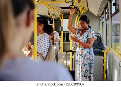 A Young Black Woman Is Traveling With A Suitcase In A Shuttle Bus And Texting On Her Smartphone