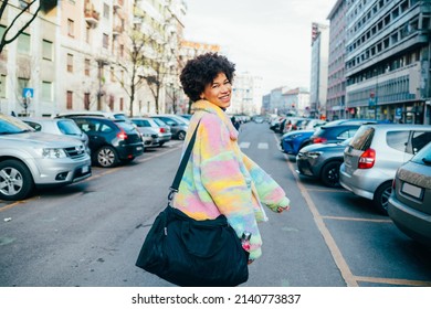 Young Black Woman Traveller Walking Outdoors City Holding Duffel Bag Smiling Having Fun