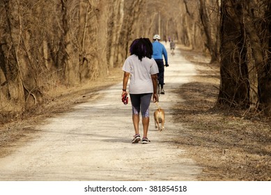 Young Black Woman Walking Her Dog On The Trail