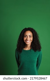 Young Black Woman With Wavy Hair Smiling And Looking At Camera Isolated Over Green Background