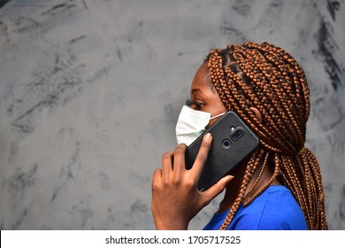 Young Black Woman Wearing A Face Mask Making A Phone Call Close Up