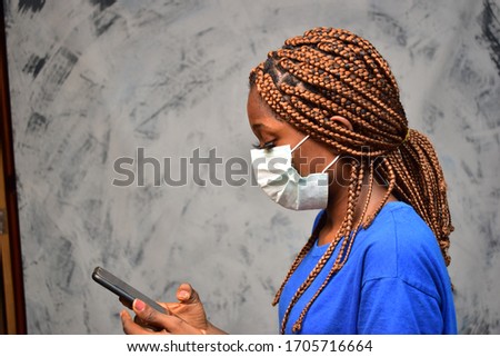 young black woman wearing a face mask making a phone call close up