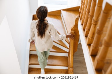 Young Black Woman Wearing Pajama Walking Upstairs At Home