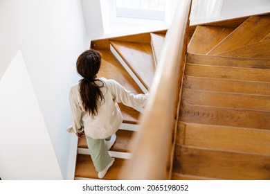 Young Black Woman Wearing Pajama Walking Upstairs At Home