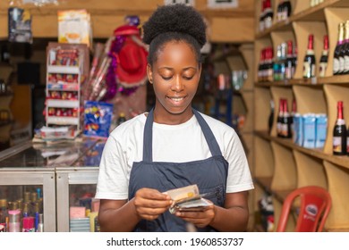 Young Black Woman Working As A Store Attendant Counting Some Money