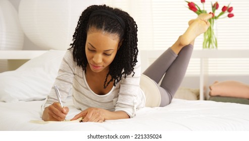 Young Black Woman Writing In Journal