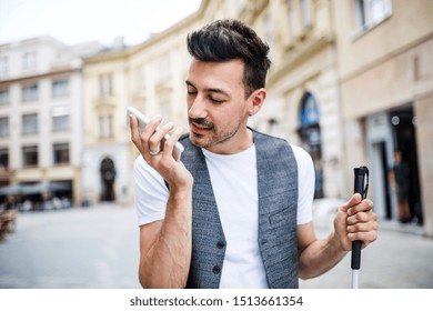 Young Blind Man With Smartphone On Street In City, Making Phone Call.