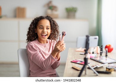 Young blogger. Happy teen girl showing her brushes and doing makeup, filming video for her channel
