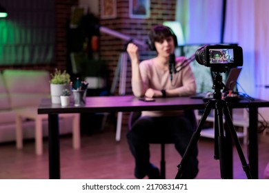 Young blogger recording online podcast discussion on camera, vlogging live channel content. Female influencer filming video conversation with audience, using streaming equipment. - Shutterstock ID 2170831471