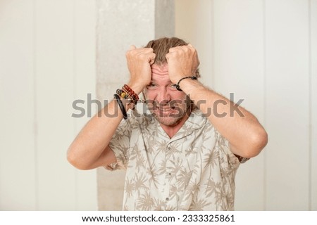young blond adult man panicking over a forgotten deadline, feeling stressed, having to cover up a mess or mistake