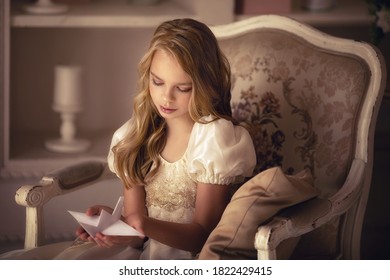 部屋の椅子に座っている若い金髪の美しい女の子