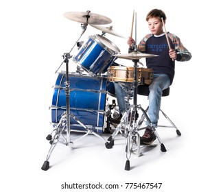 Young Blond Boy At Drum Kit In Studio Against White Background