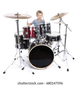 young blond caucasian boy plays drums in studio against white background