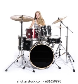young blond caucasian teenage girl plays the drums in studio against white background