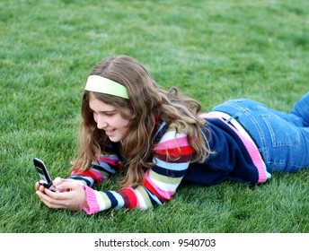 young blond girl in the park and cell phone