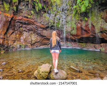 Young blond hair girl standing in front of The 25 Fontes or 25 Springs in English. It's a group of waterfalls located in Rabacal, Paul da Serra on Madeira Island.  - Powered by Shutterstock