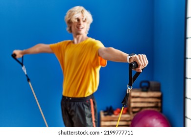 Young Blond Man Smiling Confident Using Elastic Band Training At Sport Center
