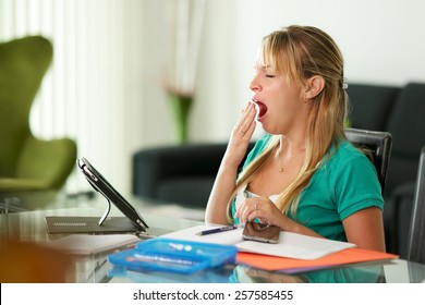 Young Blond Woman Bored While Studying, Laying On Desk And Yawning