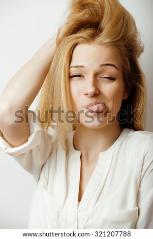 young blond woman emotional in studio isolated gesturing, making goofy faces