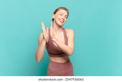 young blond woman feeling happy and successful, smiling and clapping hands, saying congratulations with an applause. sport concept - Powered by Shutterstock