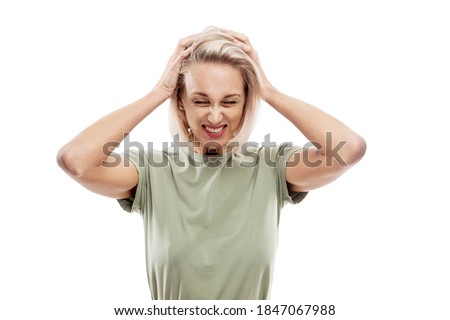 Young blond woman holding her head with her hands. Stress, pain and negativity. Isolated on a white background.