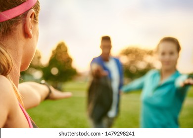 Young blond woman leading a yoga class at sunset in nature park - Powered by Shutterstock
