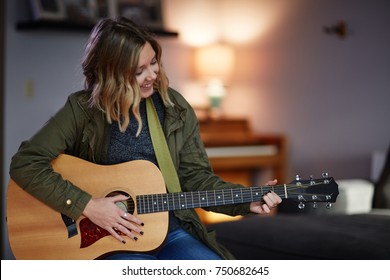 Young Blond Woman Playing Acoustic Guitar