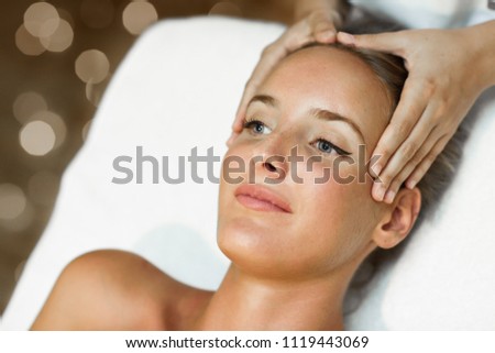 Young woman receiving a head massage in a spa center