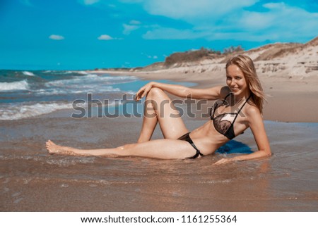 Similar – Young, long-legged woman sitting on the Baltic Sea beach